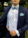 hosenträger in helllblauem stoff passend zur fliege manschettenknöpfe und einstecktuch auf blauer anzug und weißes hemd
