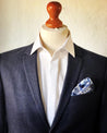 blaues seiden einstecktuch mit muster auf dunkelblauer anzug und weißes hemd