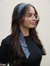 haarband dunkelblau mit blumen auf dunkles haar und schwarzes oberteil hochzeitsschmuck rockabilly